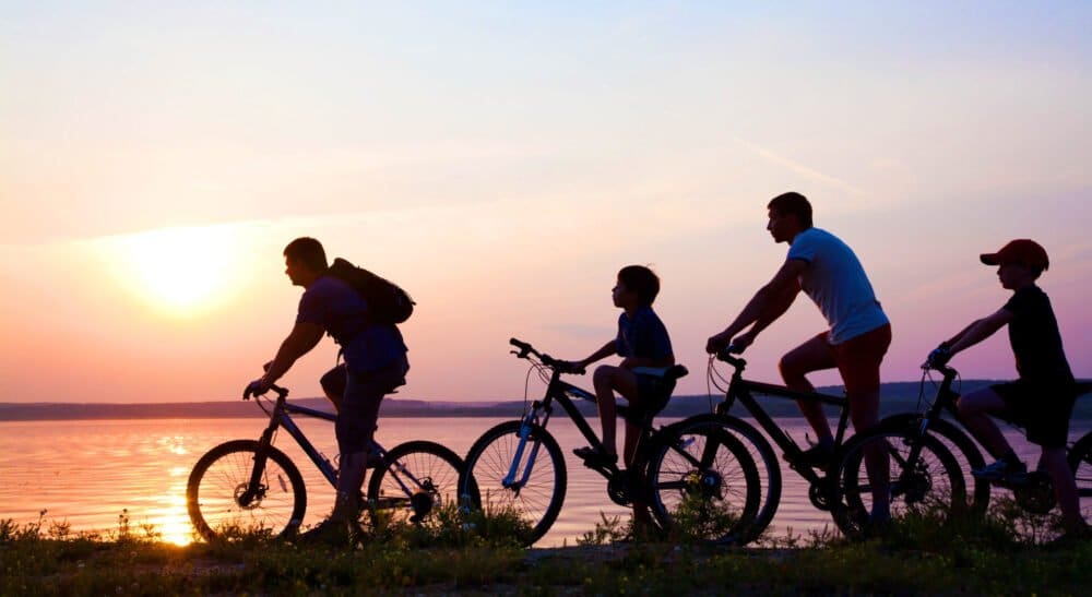 family on bicycles admiring the sunset